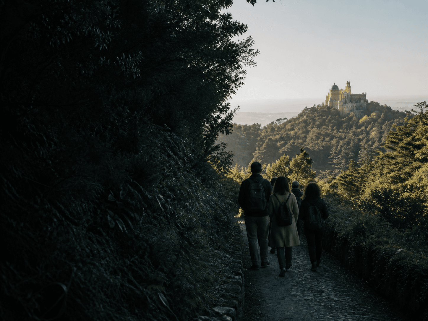 Travellers walking a route overlooking Pena Palace